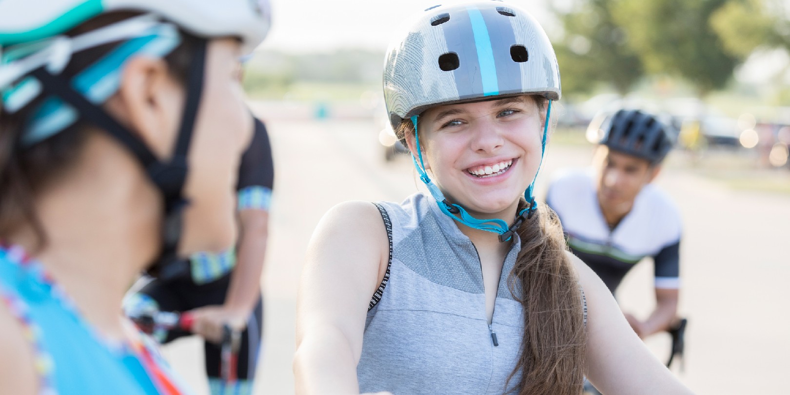 cycling-benefits the-independence A smiling preteen girl sits on her bike and talks with her unrecognizable mother before a bike race for charity event.