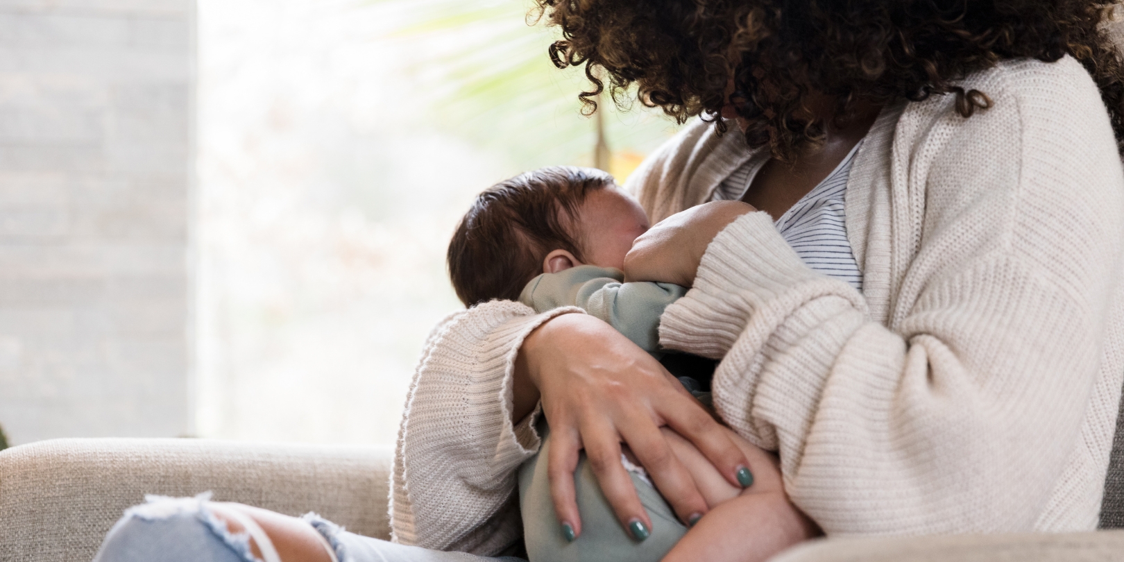 how-to-stop-breatsfeeding the-independence Unrecognizable mom holds baby snugly while breastfeeding